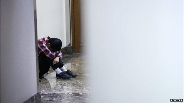 A friend of a passenger onboard the missing flight MH370 cries as he waits for news from Malaysia Airlines at the lobby of a hotel in Beijing, March 14