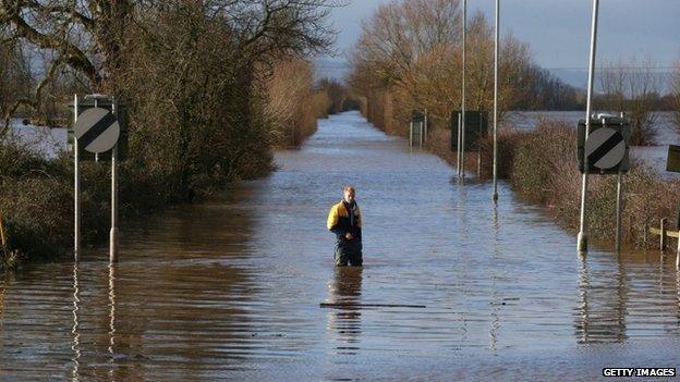 A man stands in floodwater at the A361 at Burrowbridge on the Somerset Levels on February 10