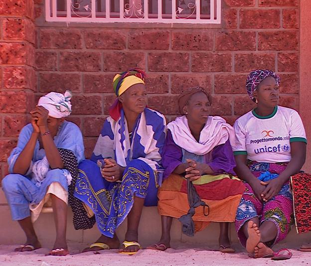 Women sit outside the hospital building