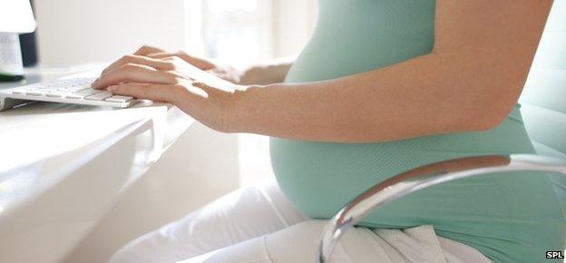 Pregnant woman at keyboard