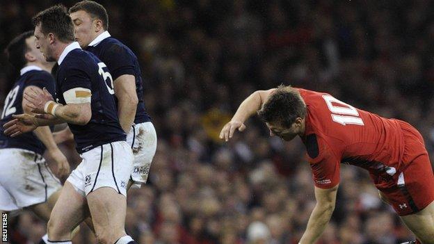 Wales' Dan Biggar is knocked to the floor by Scotland's Stuart Hogg