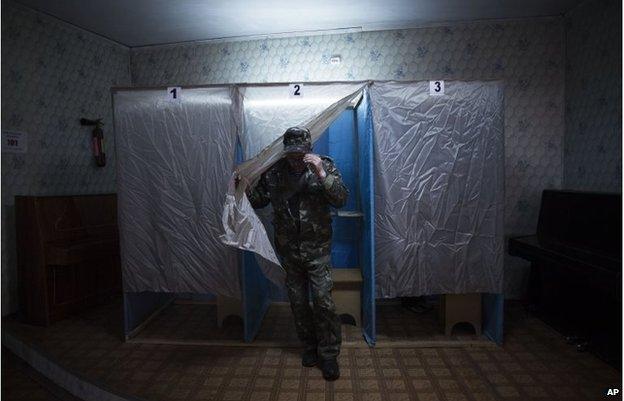 A member of a pro-Russia militia walks out of the voting cabin in Bachisaray, Ukraine, March 16