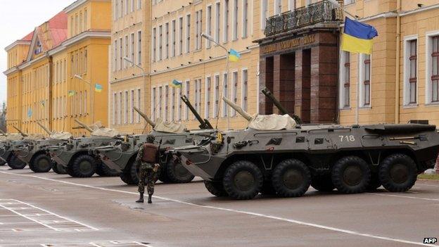 A soldier stands guard near armoured vehicles parked in front of the Ukrainian Ground Forces Academy in western Ukrainian city of Lviv