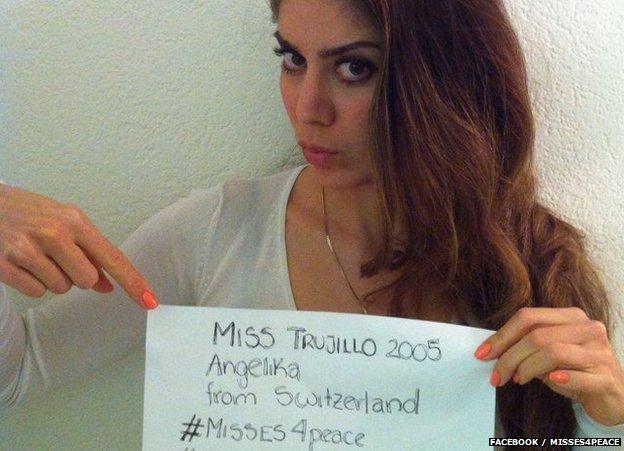 A beauty queen holds up a message of support for the people of Venezuela