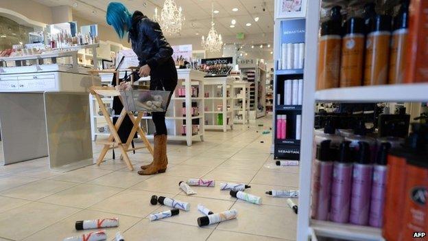 Employee Paula Anania cleans up hair care products that were knocked off the shelf in a beauty supply store in the Encino area of Los Angeles after a 4.4 earthquake jolted the area on 17 March 2014