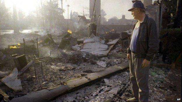 January 1994 file photo of man looking at remains of his home after the Northridge earthquake