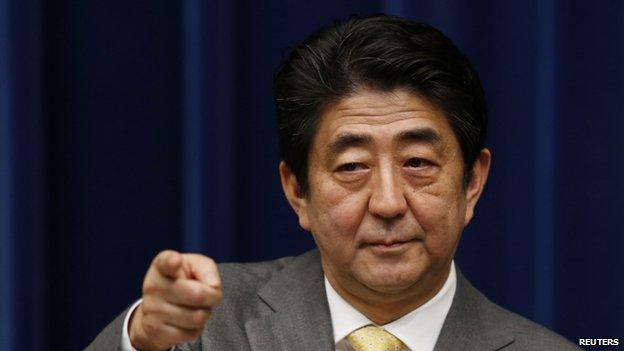 Japan's Prime Minister Shinzo Abe points to a reporter during a news conference at his official residence in Tokyo March 10, 2014, a day before the third anniversary of the 11 March 2011 earthquake, tsunami and nuclear crisis that struck the nations north-east