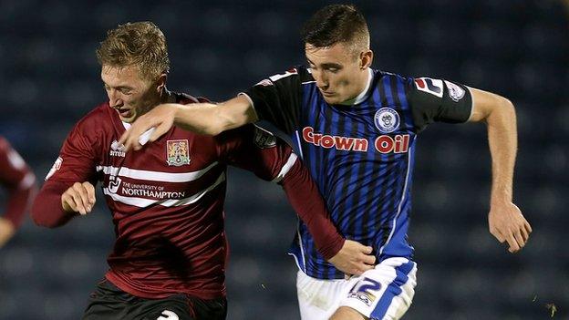 Northampton's Luke Norris is challenged by Rochdale scorer Matthew Lund, who was sent off for celebrating his goal.