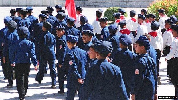 Boys in military uniforms marching