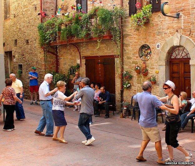 Couples dancing in a town square