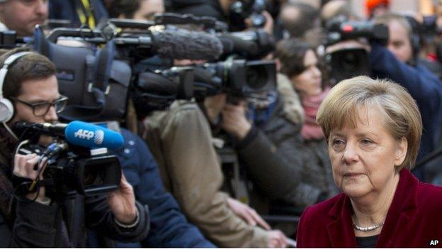 German Chancellor Angela Merkel walks past reporters