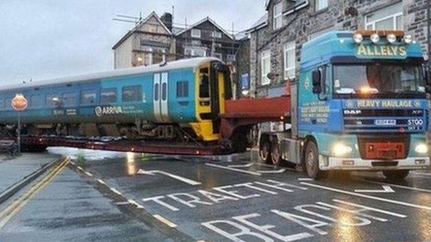 Trains stranded on a stretch of flood-damaged rail line had to be moved by road