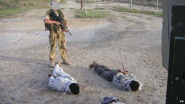 The Al-Sweady Inquiry undated handout image of detained Iraqis being guarded by a British soldier .