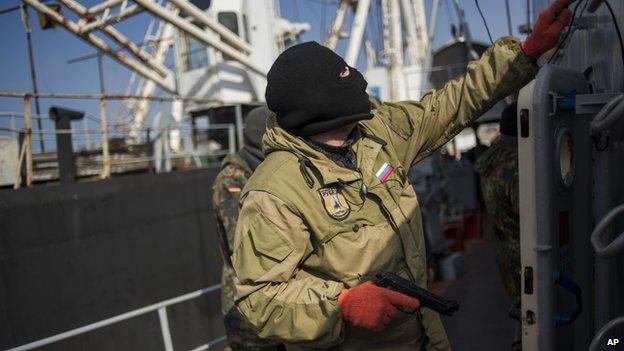 A pro-Russia forces man holds a gun during seizure of the Ukrainian corvette Khmelnitsky in Sevastopol, Crimea (March 20, 2014)