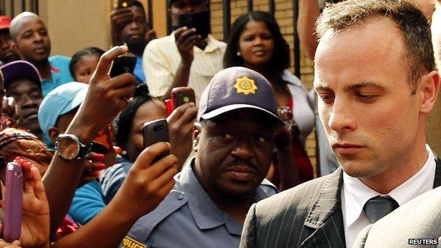 Oscar Pistorius is escorted out of the Pretoria courtroom on day 12 of his trial