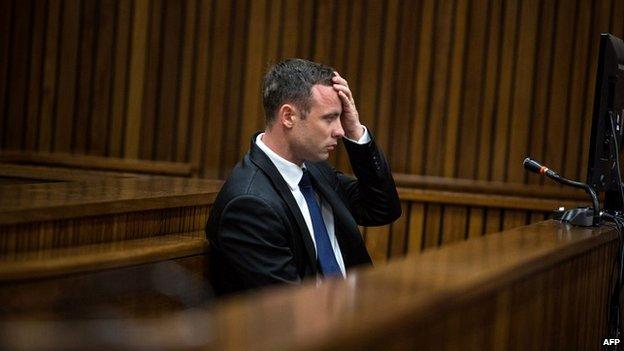 Oscar Pistorius holds his hand to his head during evidence on day 11