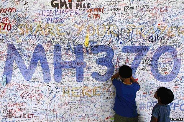 Children write messages on a wall at Kuala Lumpur Airport