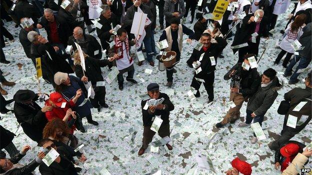 Demonstrators from opposition CHP party hold up fake euro notes in protest against Turkish Prime Minister Recep Tayyip Erdogan, who is beset by allegations of bribery and corruption (1 March)