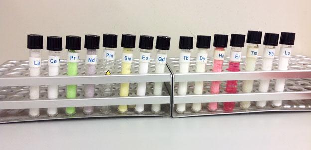 A rack of test tubes each showing various different colours