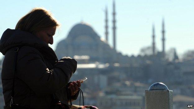 A Turkish woman looks at her smartphone in the Eminonu district of Istanbul