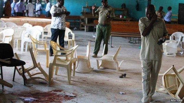 Police officers inspect blood stains on the floor of a church in Likoni. Photo: 23 March 2014