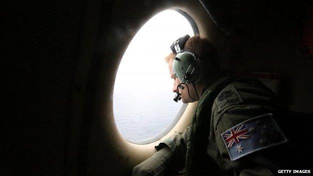 Aircrew look out of a window of a Royal Australian Air Force AP-3C Orion