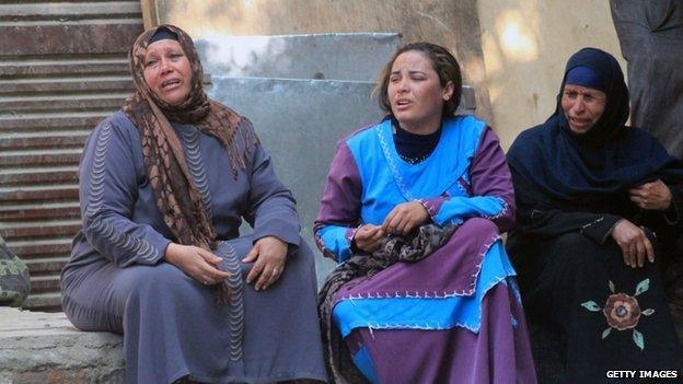 Egyptian relatives of supporters of ousted president Mohamed Morsi cry sitting outside the courthouse in the central Egyptian city of Minya