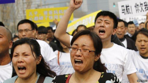 Family members of passengers on board Malaysia Airlines MH370 shout slogans during a protest in front of the Malaysian embassy in Beijing, on 25 March 2014