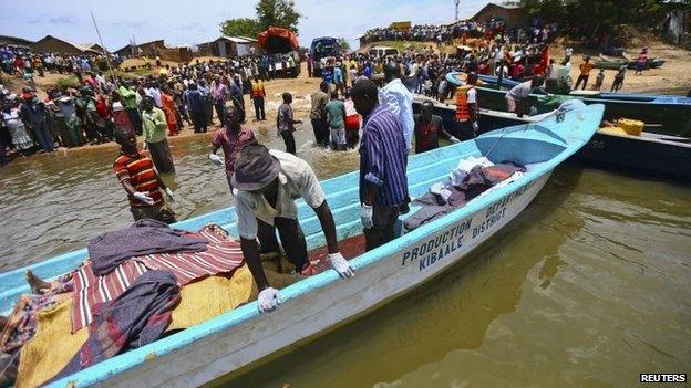 Volunteers prepare to carry the bodies of people killed after a boat disaster on Lake Albert in Uganda (24 March 2014)