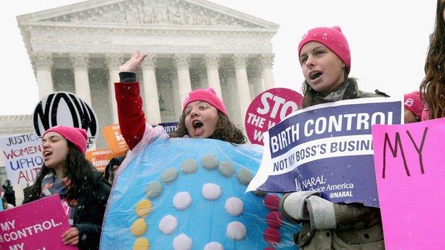 Feminist demonstrators hold signs outside the US Supreme Court building on 25 March, 2014.