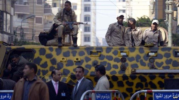 Police officers deployed outside the Minya Central Court on 25 March 2014