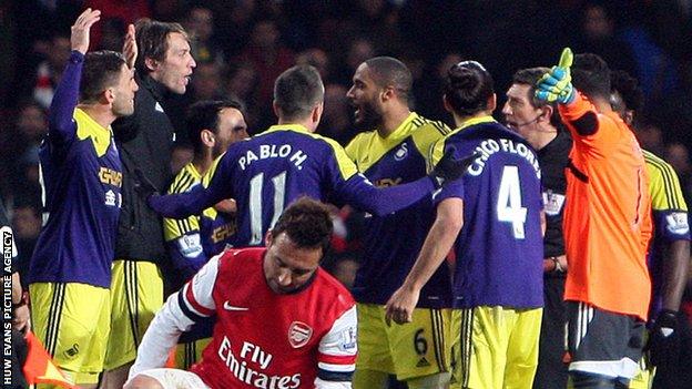 Swansea players surround referee Lee Probert after the final whistle