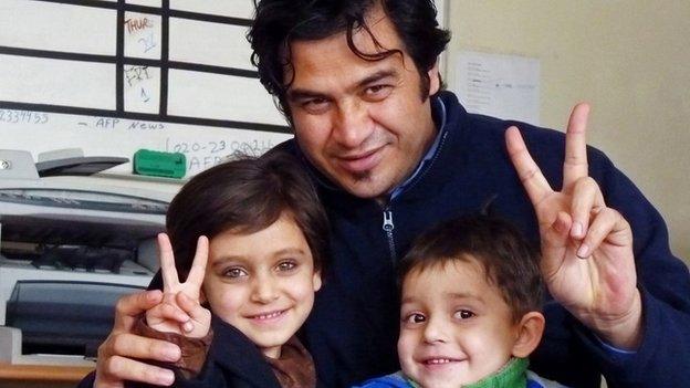 Sardar Ahmad poses for a photograph with his daughter Nilofar and son Omar at the AFP office in Kabul in 2012