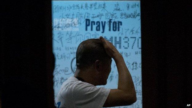 One of the relatives of Chinese passengers on board Malaysia Airlines Flight 370 rubs his head at a hotel in Beijing on 26 March 2014