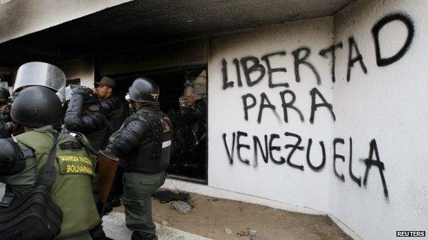 National guards inspect the national electoral headquarters in Maracaibo after a fire which, according to government officials, was set by anti-government protesters on 25 March, 2014