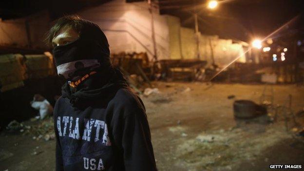 A young protester mans a barricade before dawn on 9 March, 2014 in San Cristobal