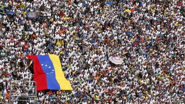 Opposition supporters hold a national flag during a rally against President Nicolas Maduro's government in Caracas (22 March 2014)