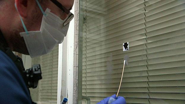 A forensics expert seeks to get fingerprints from a window