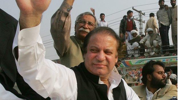 Former Pakistani Prime Minister Nawaz Sharif , left, waves to supporters from his car as his motorcade makes its way along a highway to a public meeting in Phoolnagar, Pakistan, Sunday, Dec. 2, 2007