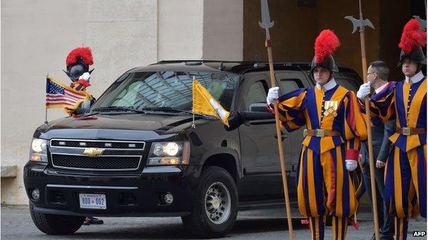 President Obama's car enters the Vatican, flanked by Swiss Guard members