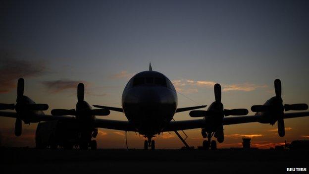 A Royal Australian Air Force AP-3C Orion aircraft is pictured in the sunset twilight after returning from a search flight for Malaysia Airlines flight MH370, at RAAF Base Pearce near Perth on 27 March 2014