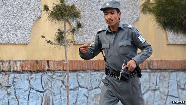 An Afghan policeman runs to the site of an attack in Kabul