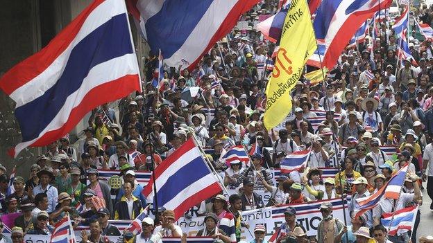 Thai anti-government protesters hold national flags and banners fill the street during a mass rally in Bangkok, Thailand on 29 March 2014.