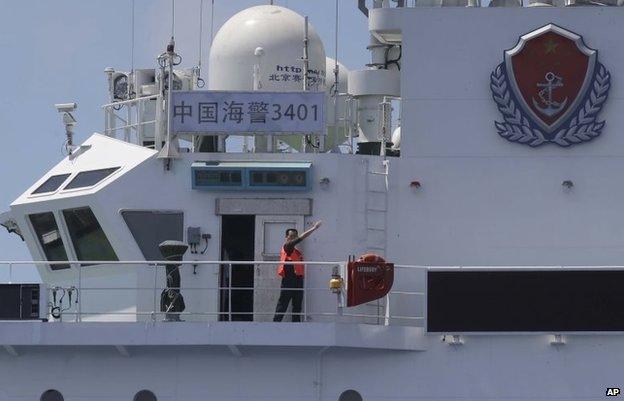 A crewman of the China Coast Guard vessel gestures at the Philippine Government vessel to move away as the latter tries to enter the Second Thomas Disputed Shoals