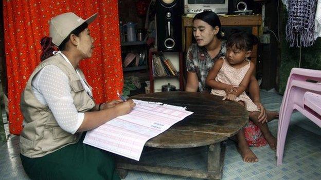 A Myanmar census enumerator asks questions to a housewife while collecting information in Dala township on 30 March 2014, in Yangon, Myanmar