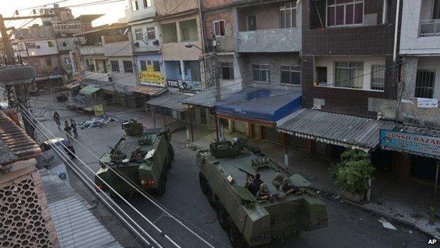 Brazilian soldiers take position during an operation to occupy the Mare slum complex in Rio, 30 March