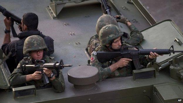 Brazilian soldiers take position during an operation to occupy the Mare slum complex in Rio, 30 March