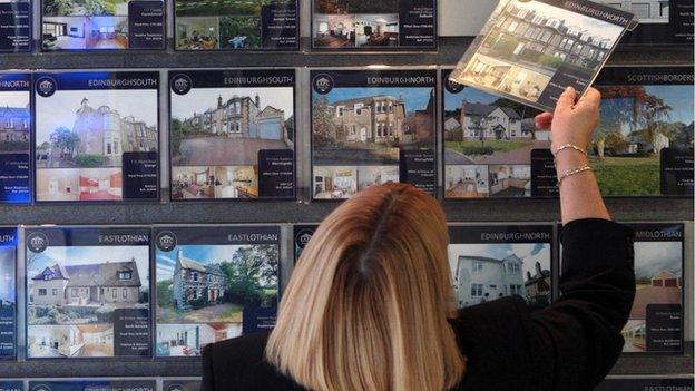 Woman looking in estate agent's window