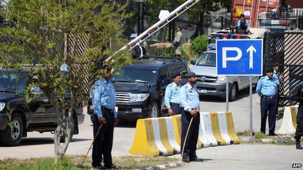 Pakistani police stand guard as the vehicle (C) carrying former military ruler Pervez Musharraf leaves a special court after a hearing in Islamabad on March 31, 2014.