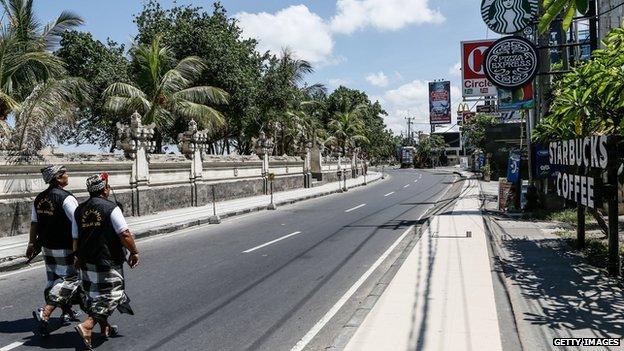 An empty street patrolled by traditional guards on Nyepi in Bali